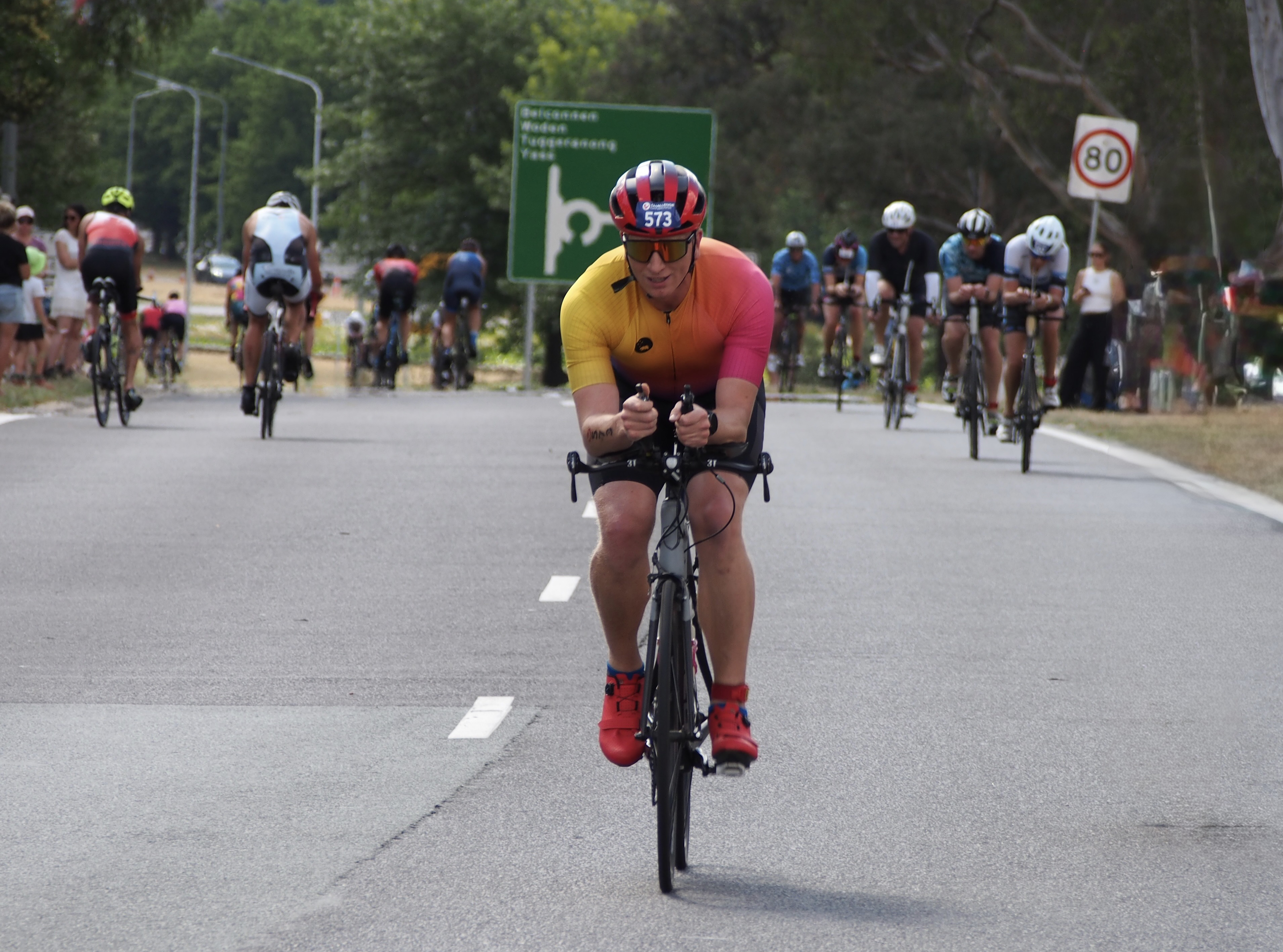 Triathlon Front view of a man on a bicycle with a riders behind him