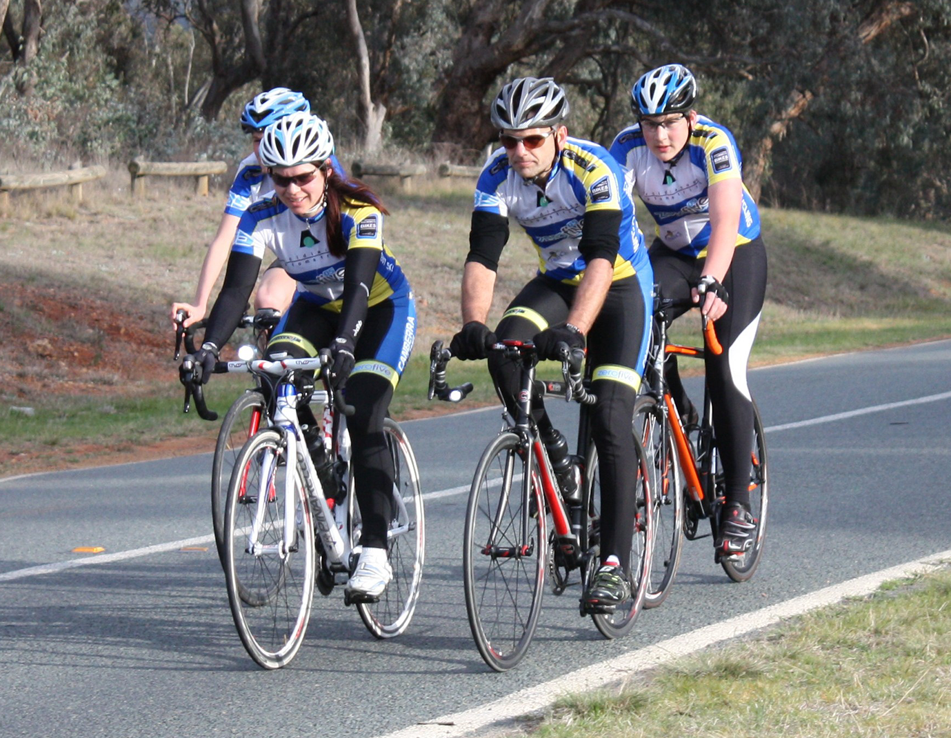 riders-home Four cyclist riding together on the road.