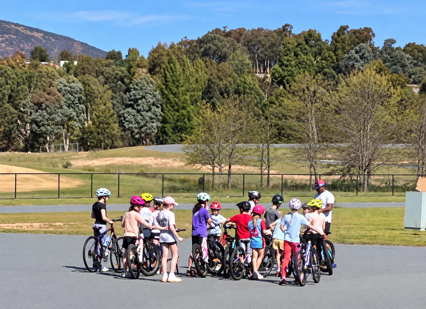 Group of junior cyclists with their bikes during a coaching session at Stromlo Forest Park in Canberra
